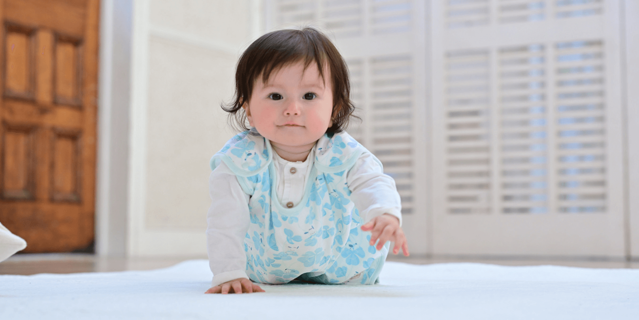 ポチャッコのスリーパーを着てハイハイしてる女の子の赤ちゃん